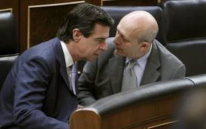 El ministro de Industria, Energía y Turismo, José Manuel Soria (i), y el ministro de Educación, José Ignacio Wert (d), conversan al inicio de la sesión de control al Gobierno del pleno del Congreso.