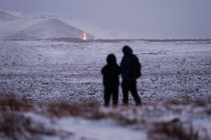Dos personas observan la lava tras la erupción volcánica cerca de la ciudad de Grindavik, en la península de Reykjanes (Islandia). 