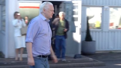 WikiLeaks founder Julian Assange walks to board a plane at a location given as London, Britain, in this still image from video released on June 25.