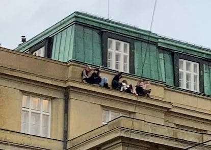Estudiantes de la facultad de Filosofía y Letras de la Universidad Carolina se refugian en una cornisa durante el tiroteo de este jueves en Praga.