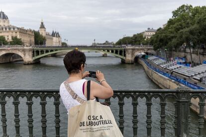 Una mujer toma fotografías de las gradas instaladas para seguir las competiciones deportivas.