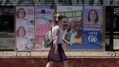 Una mujer pasa delante de una valla con los carteles electorales de los principales partidos españoles al Parlamento Europeo, este lunes en Ronda.
