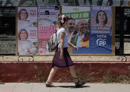 Una mujer pasa delante de una valla con los carteles electorales de los principales partidos españoles al Parlamento Europeo, este lunes en Ronda.