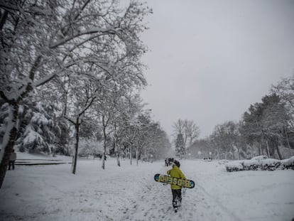 Un joven con una tabla de 'snow', en el parque del Paraíso de Madrid durante el temporal 'Filomena'.