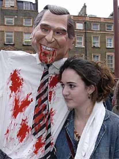 Una joven se manifiesta en Londres con una figura de cartón de Bush.