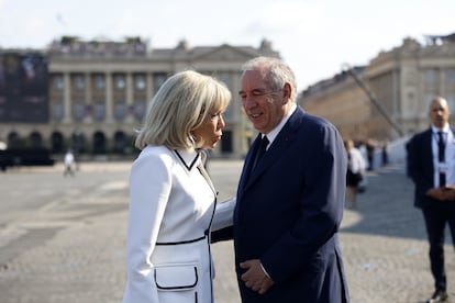 La esposa de Macron, Brigitte Macron, charla con el primer ministro François Bayrou, a su llegada al desfile que conmemora la toma de la Bastilla.