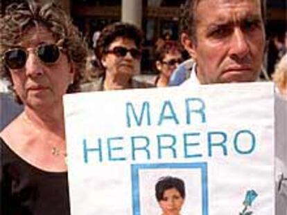 Los padres de Mar Herrero sostienen una pancarta con la foto de su hija.