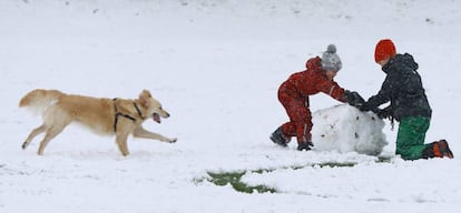 Una familia construye un muñeco de nieve en un parque en el norte de Londres (Inglaterra).