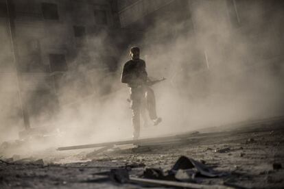 Un combatiente rebelde sirio corre tras atacar un vehículo armado del Ejército en Alepo (2012). La exposición está organizada por National Geographic.