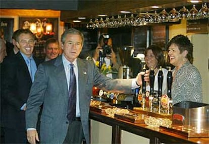 Bush agarra un grifo de cerveza en un <i>pub</i> de Sedgfield, feudo de Blair, que aparece tras el presidente de EE UU.