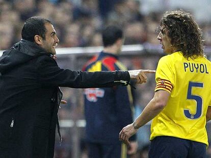 Guardiola da instrucciones a Puyol durante el encuentro con el Atlético.