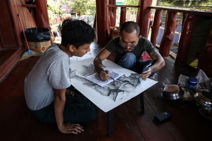 Soe Myint trabaja en una obra de arte con uno de sus alumnos en el balcón del centro de rehabilitación en el que se recupera de sus heridas.