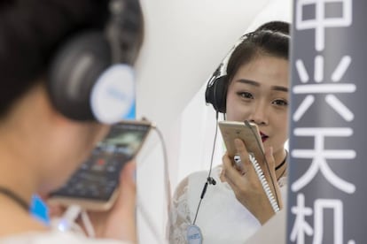 Una azafata de ZTE en el Mobile World Congress de Shanghái hace una demostración de la calidad de grabación de sonido del Axon 7 cantando una canción en una cabina