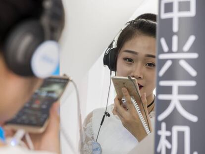 Una azafata de ZTE en el Mobile World Congress de Shanghái hace una demostración de la calidad de grabación de sonido del Axon 7 cantando una canción en una cabina