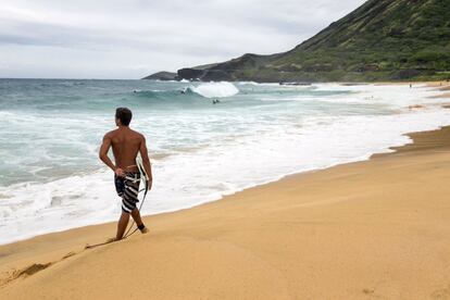 Un surfero en la playa de Sandy Park en Honolulu, Hawái (EE.UU)