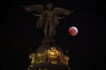 La superluna de sangre vista junto a la estatua de la 'Victoria Alada' en Madrid (España).