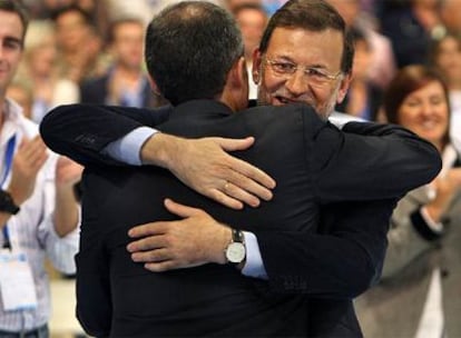 Mariano Rajoy y Francisco Camps se abrazan, ayer, en la clausura del congreso del PP en Valencia.