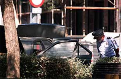Un guardia urbano inspecciona el coche usado por ETA en Barcelona que fue hallado ayer.