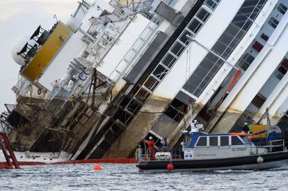 Miembros del equipo de los trabajos de reflote del Costa Concordia observan una parte del barco que hab&iacute;a estado sumergida hasta hoy.