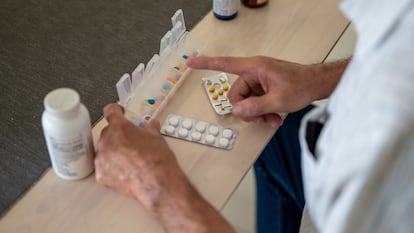 Un hombre preparando sus pastillas para la semana