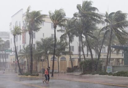 Pessoas caminham pelas ruas enquanto o vento e a chuva começam a golpear, antes da chegada do furacão a Miami.