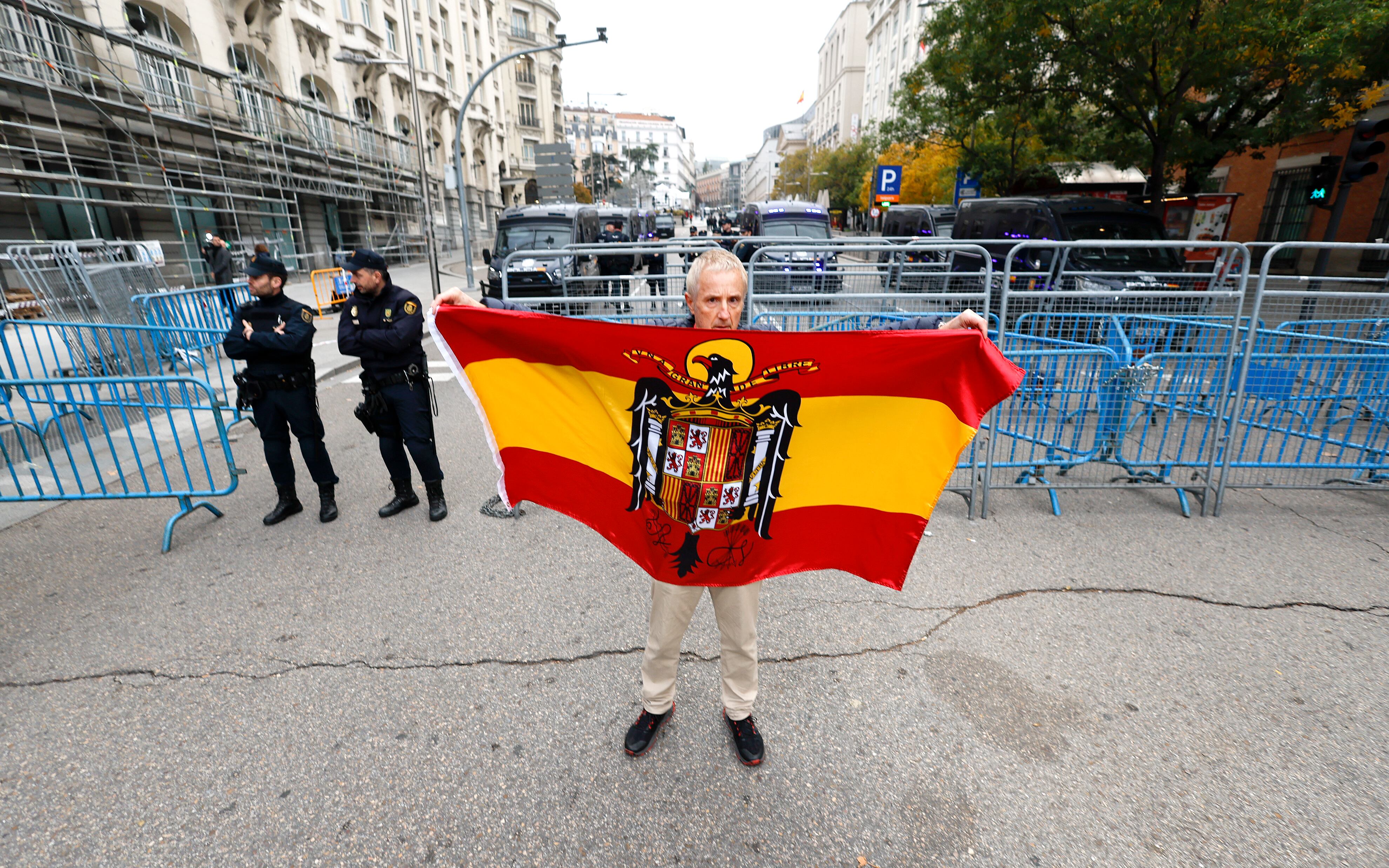 Un hombre muestra una bandera franquista frente al dispositivo policial en la carrera de San Jerónimo de Madrid, este miércoles.