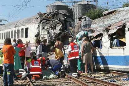 Los servicios de emergencia y varios pasajeros tratan de ayudar a las víctimas del tren siniestrado ayer en Villada, cerca de Palencia.