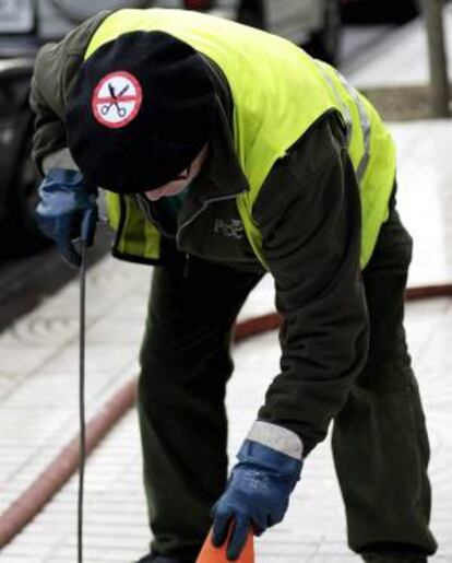 Un empleado exhibe una boina con una pegatina contra los recortes.