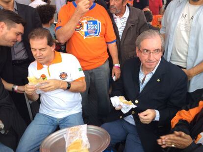 Paulo Pereira (à esq.) e Eduardo Cunha comem pastel no ato da Força Sindical.