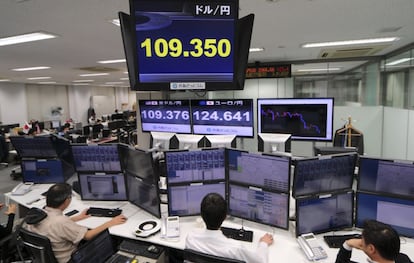 Varios operadores japoneses trabajan delante de pantallas que marcan el tipo de cambio entre el yen y el d&oacute;lar estadounidense.
 