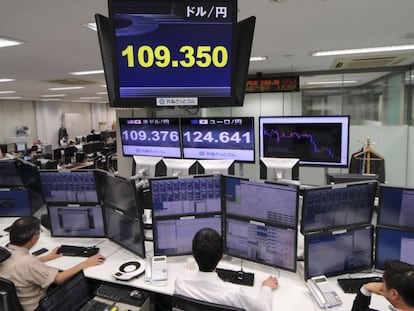 Varios operadores japoneses trabajan delante de pantallas que marcan el tipo de cambio entre el yen y el d&oacute;lar estadounidense.
 