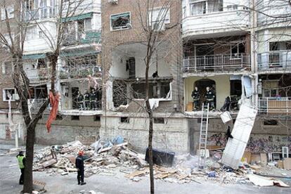 Los bomberos retiran escombros en la parte trasera de los números 55 y 57 de la calle de Valencia, donde estaba el piso en el que se produjo la explosión.