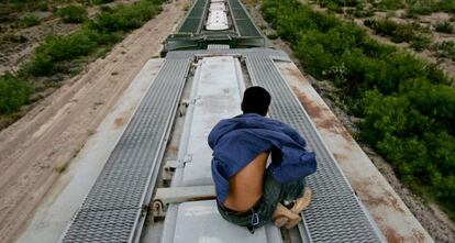 Un inmigrante viaja sobre en un tren en M&eacute;xico hacia EE UU.