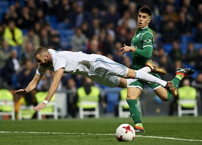 Karim Benzema cae al campo en una jugada del partido.