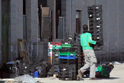 Un joven apila los envases en la zona del almacenes donde se produce la venta de las cajas.