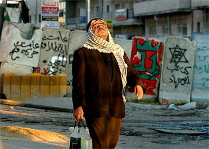 Un palestino camina junto a un muro que separa Jerusalén de los territorios palestinos en Abu Dis.