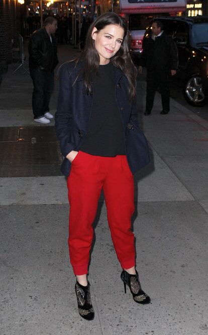 Pantalones rojos a prueba de madre y de suegra. Si en lugar de una trenca, a Katie Holmes le diera por un abrigo o blazer de terciopelo de terciopelo, o cazadora brocada a conjunto con sus botines, ya tendría look para Nochebuena.