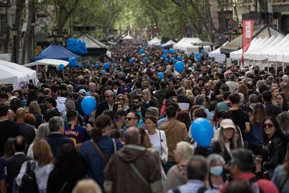 Centenares de personas pasean por La Rambla de Barcelona durante Sant Jordi, este domingo. 
