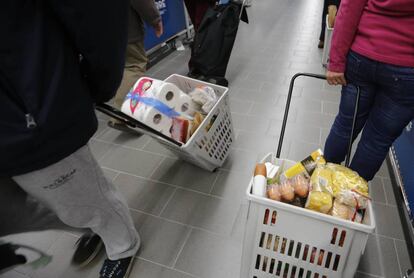 Varias personas haciendo la compra en un supermercado.