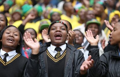 Asistentes cantan y bailan durante el servicio conmemorativo de Winnie Mandela en el estadio de Orlando en Soweto, el 11 de abril de 2018.