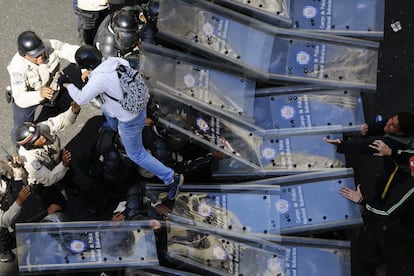 Uma pessoa pula o cordão policial.