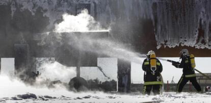 Dos bomberos, ayer, durante el simulacro de accidente con fuego real en el aeropuerto de L&#39;Altet.