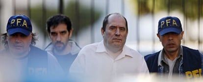 El abogado Emilio Rodríguez Menéndez, esposado y escoltado por policías argentinos tras su detención.