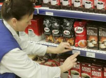 Una empleada de un supermercado cambia los precios del café de coronas a euros en un supermercado en Tallinn (Estonia). EFE/Archivo