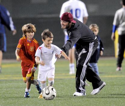 Beckham juega al fútbol con sus hijos Romeo (izq.) , vestido con el uniforme de la selección española, y Cruz, con el de la selección inglesa, en Los Ángeles.