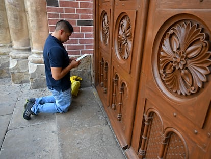 Homem reza às portas da Basílica do Senhor dos Milagres na Colômbia.