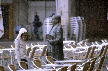 El cambio brusco de temperatura ha llegado a ciudades como Segovia donde, a mediodía de hoy, ha comenzado a nevar debilmente, registrándose la primera precipitación de nieve de la temporada, como se aprecia en la imagen captada en la Plaza Mayor, junto al monumento en recuerdo del poeta Antonio Machado. 