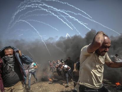 Varios palestinos corren para refugiarse de un ataque de las fuerzas israelíes.