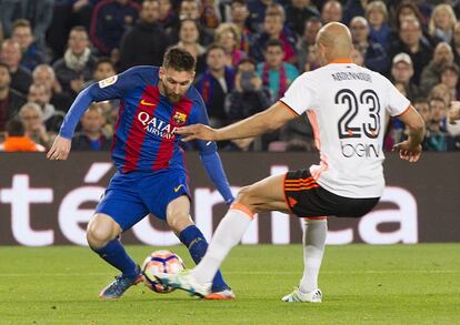 El delantero argentino del FC Barcelona Lionel Andrés Messi (i) lucha el balón con el tunecino Aymen Abdennour, del Valencia CF.