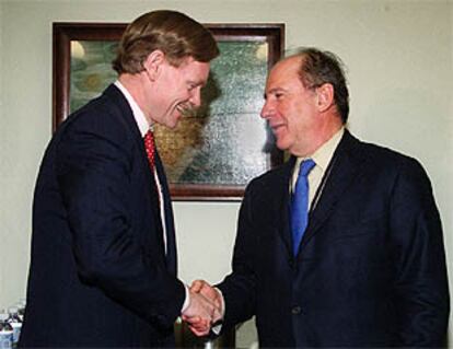 El representante de comercio Robert Zoellick felicita al ministro de Economía Rodrigo Rato en la reunión del FMI.